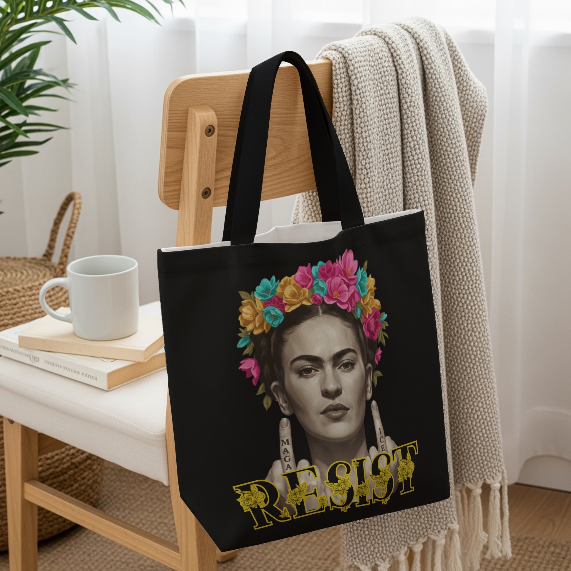 Frida Kahlo portrait with flowers and "RESIST" text on black tote bag.