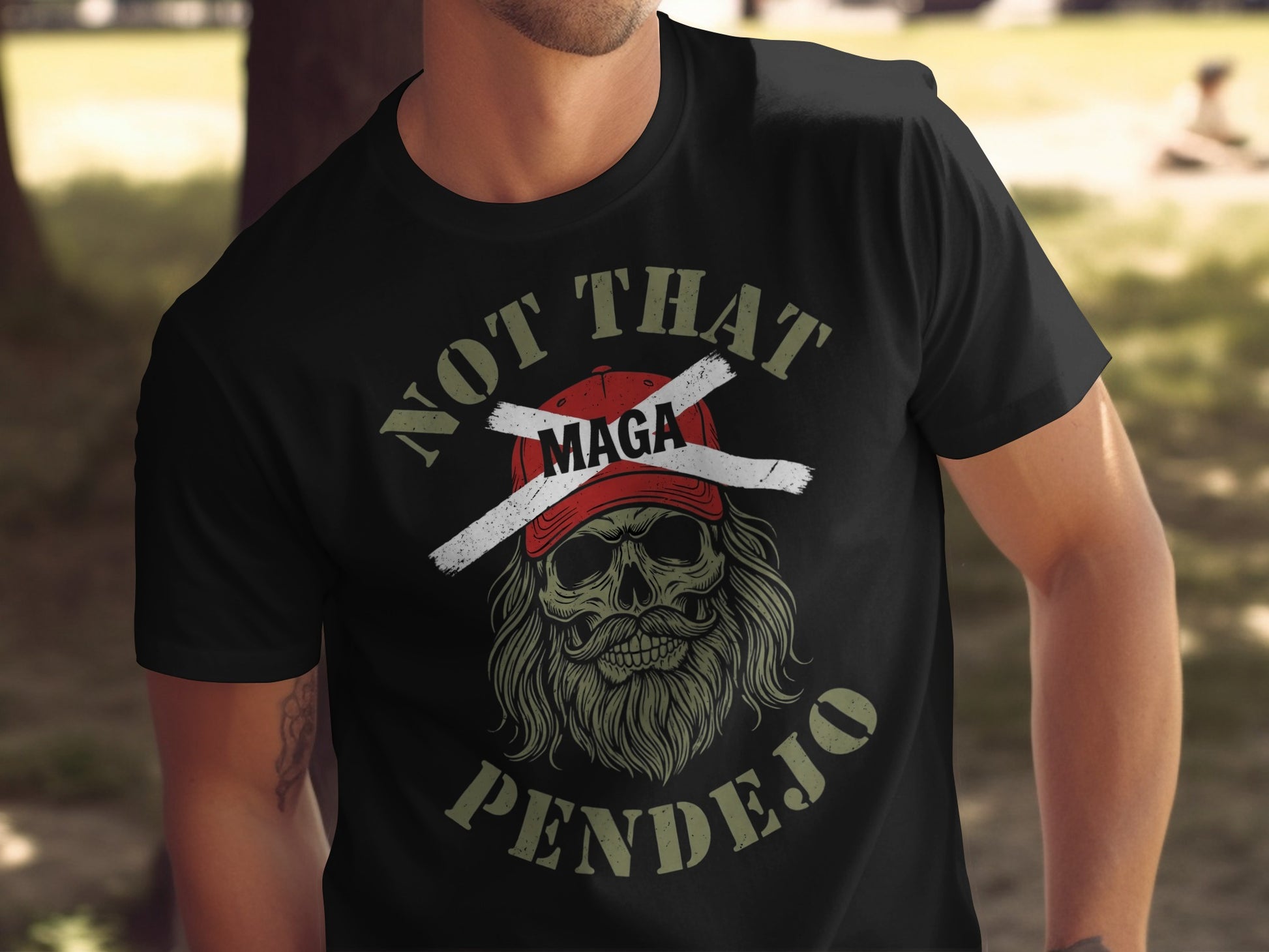 Black t-shirt with skull wearing a red hat crossed out, text "NOT THAT MAGA PENDEJO".
