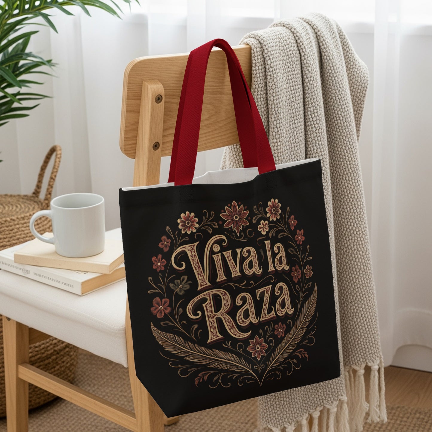 Black tote bag with "Viva La Raza" text surrounded by floral and feather design.