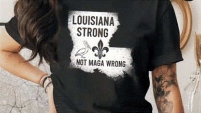 A person wearing a black t-shirt with a graphic design that says "LOUISIANA STRONG NOT MAGA WRONG".