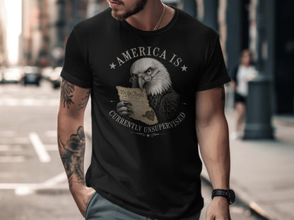 Eagle wearing glasses holding Declaration of Independence on dark t-shirt.