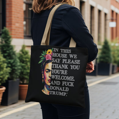 Black tote bag with Frida Kahlo graphic and text reading "In this house we say please thank you you're welcome. And fuck Donald Trump."