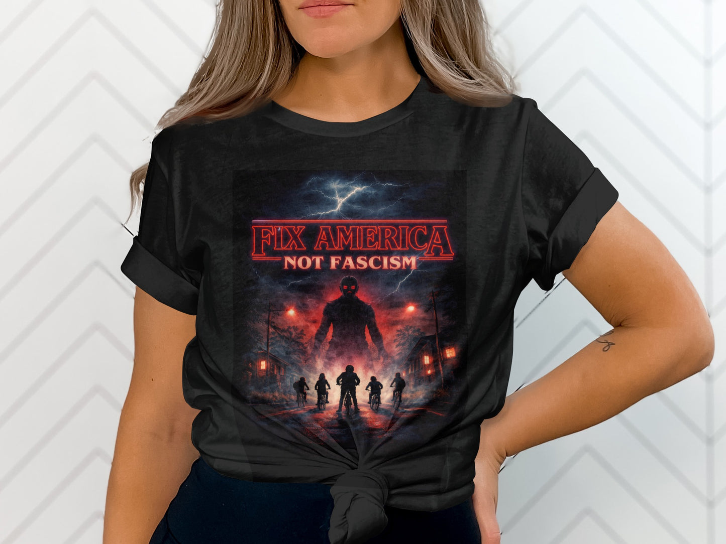 Black t-shirt with "Fix America Not Fascism" text and shadowy figures.