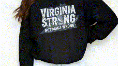 A person wearing a black hoodie with the text "VIRGINIA STRONG NOT MAGA WRONG" printed on it.