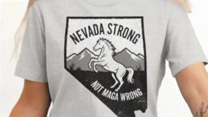 A person wearing a grey t-shirt with a graphic design featuring a horse and mountains, along with the text "NEVADA STRONG NOT MAGA WRONG".