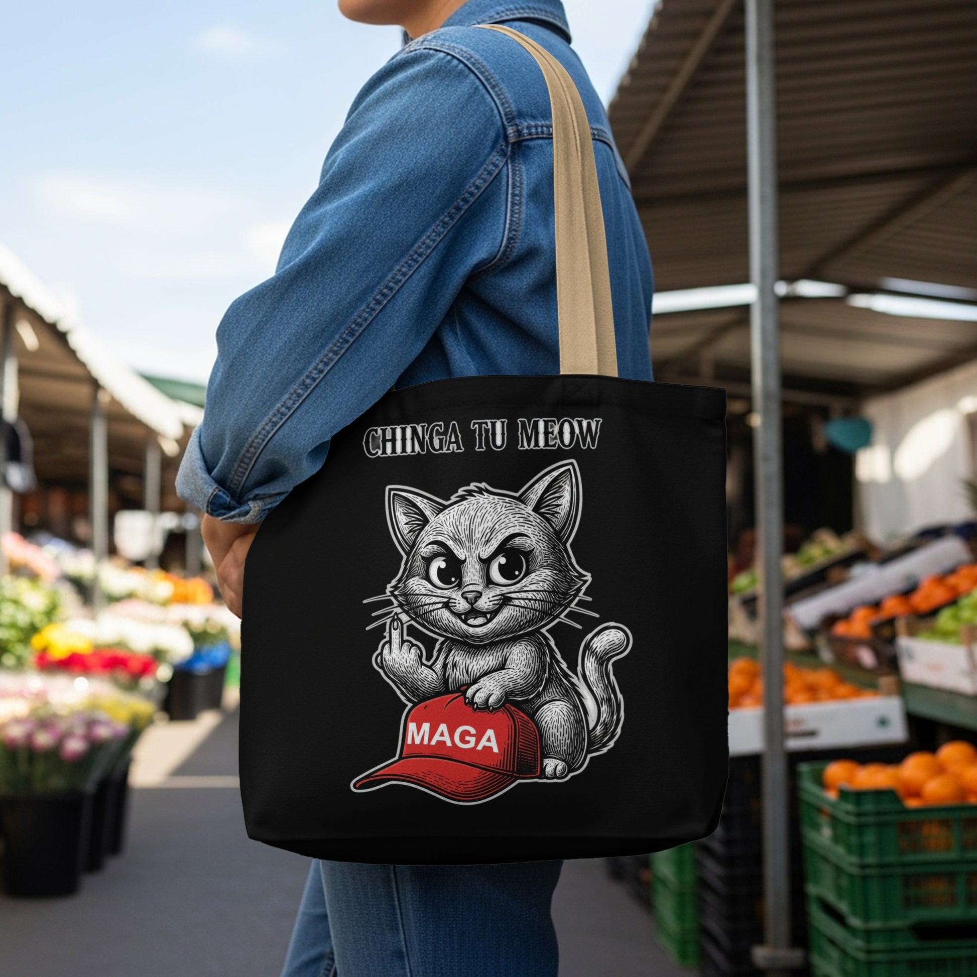 Black tote bag with a cartoon cat giving the middle finger over a MAGA hat.