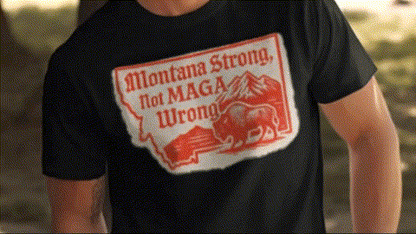 A person wearing a black t-shirt with a red and white graphic that says "Montana Strong, Not MAGA, Wrong" printed on it.