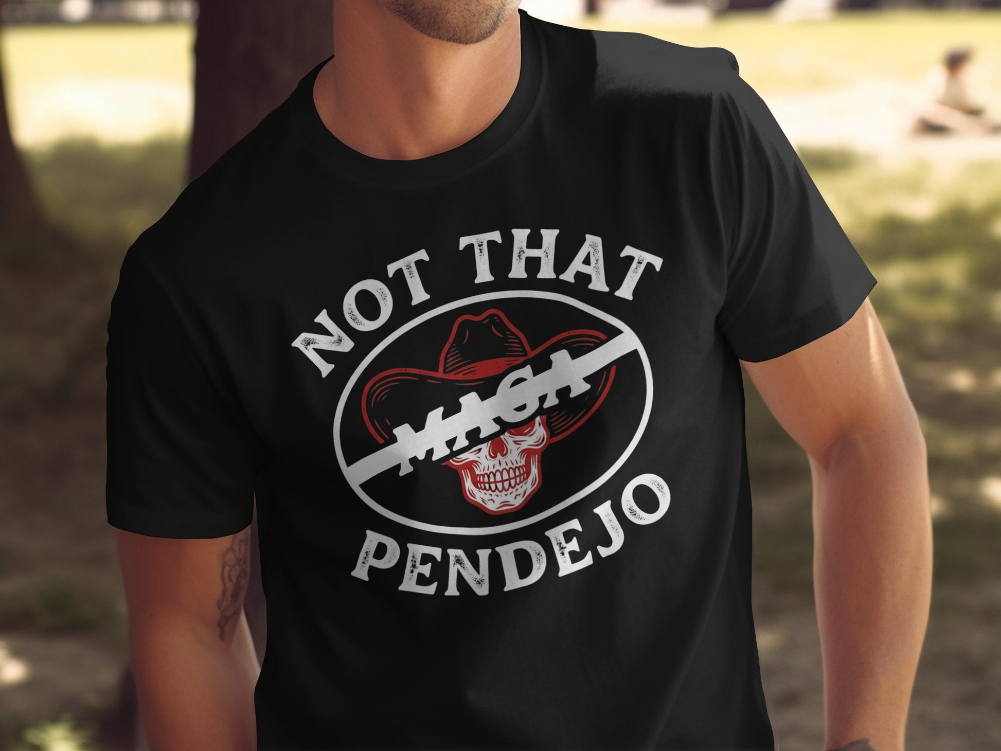 Black t-shirt with white text "NOT THAT MAGA PENDEJO" and a skull in a cowboy hat.