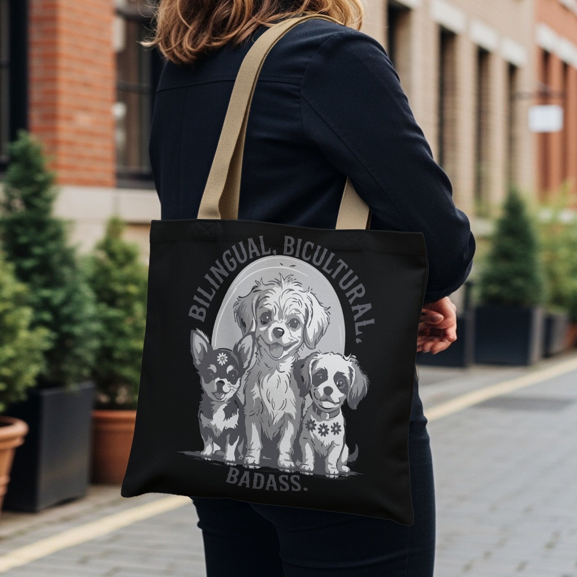 Black tote bag with "Bilingual. Bicultural. Badass." text and three chihuahua dogs.