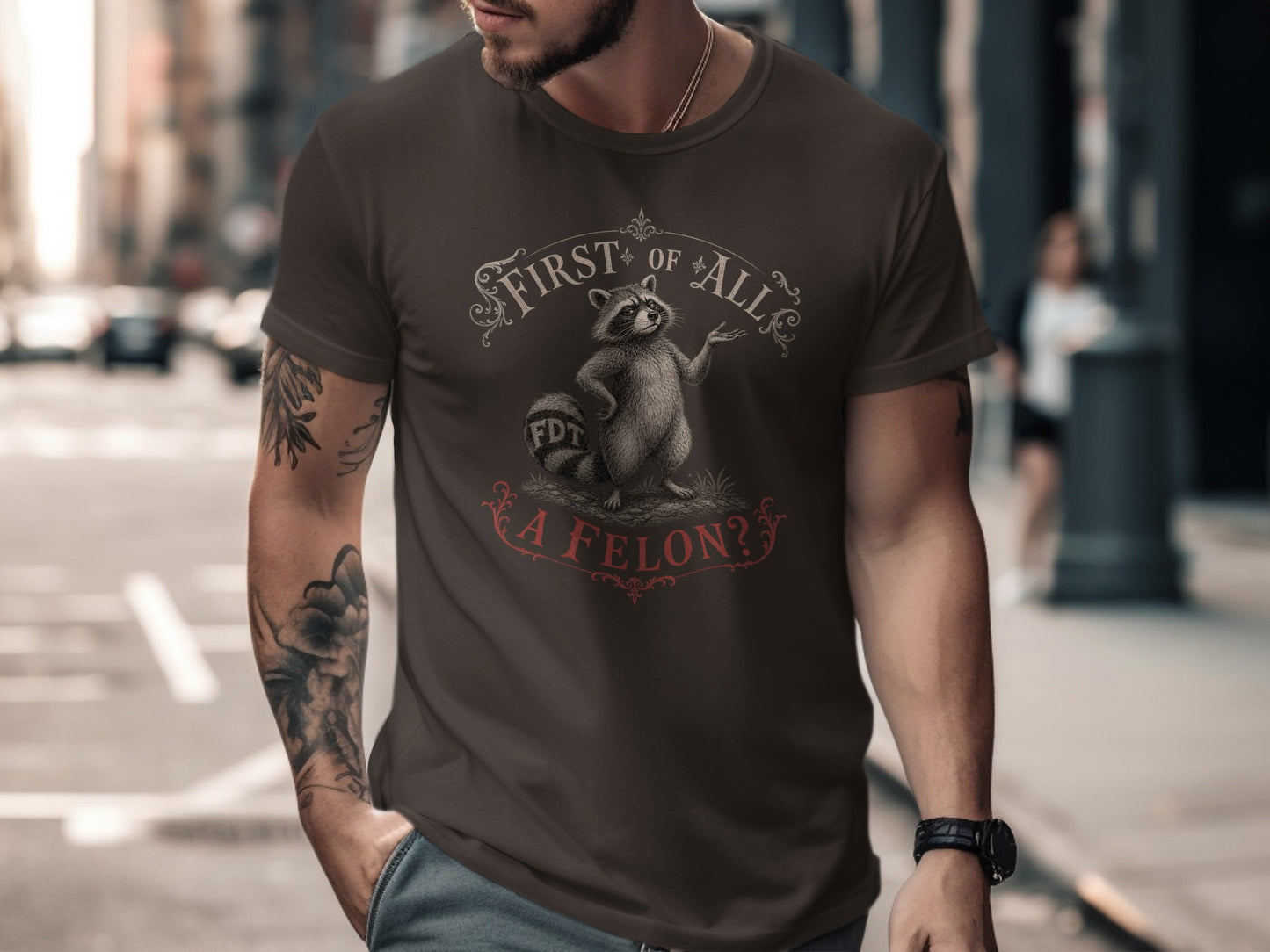 Dark brown t-shirt with "First of All, a Felon?" text and cartoon raccoon.