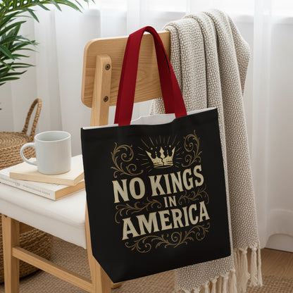 Black tote bag with "No Kings In America" text and ornate crown design.