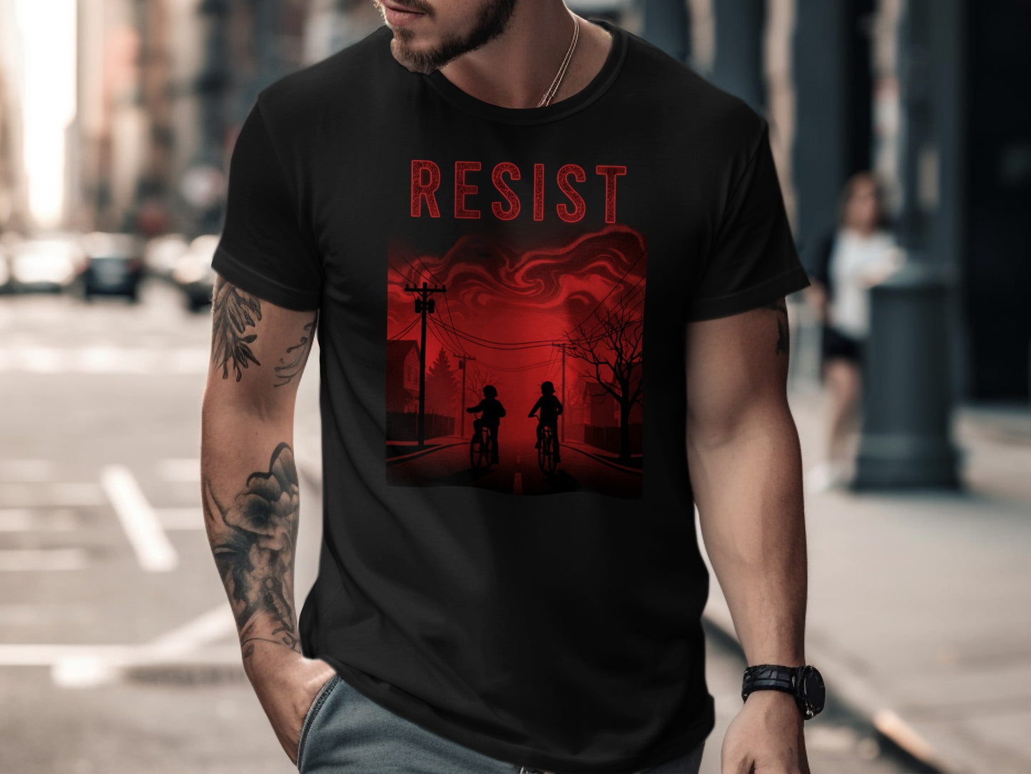 Black t-shirt with red "RESIST" text and graphic of two figures on bikes.