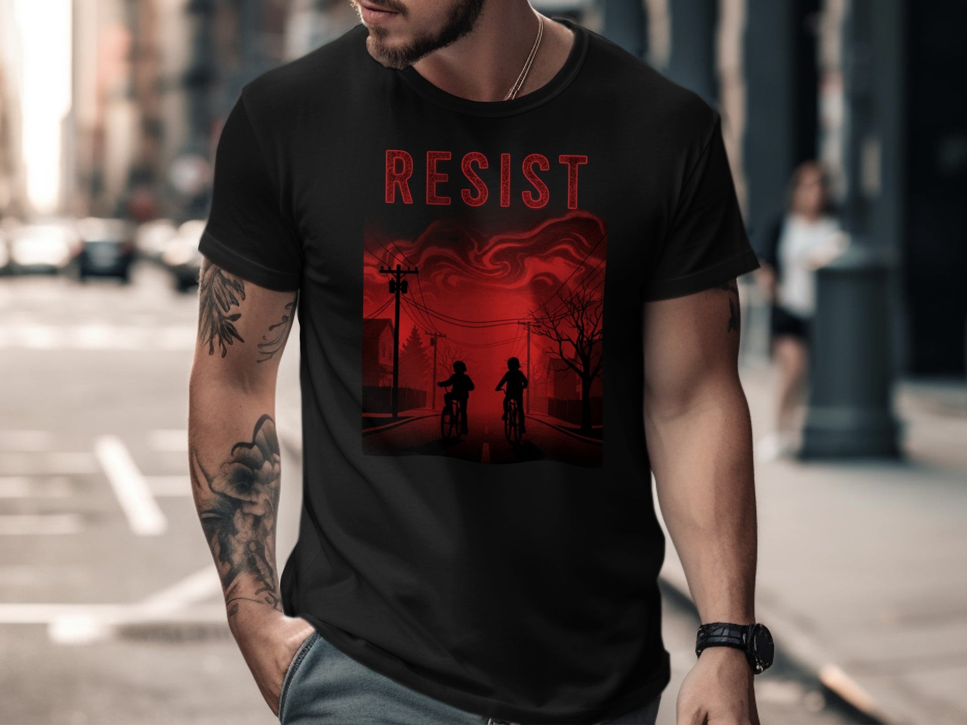 Black t-shirt with red "RESIST" text and graphic of two figures on bikes.