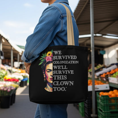 Black tote bag with Frida Kahlo art and quote "We survived colonization, we'll survive this too."