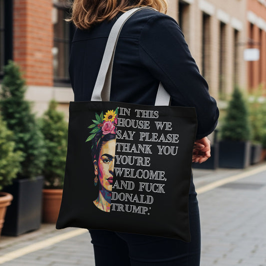Black tote bag with Frida Kahlo portrait and text about politeness and Trump.