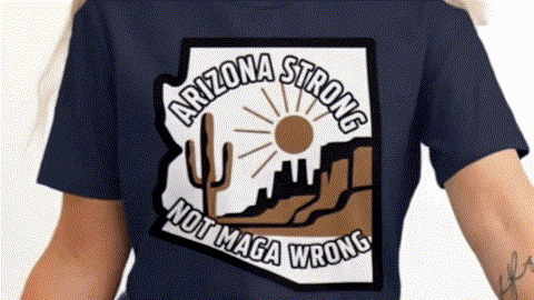 A person wearing a dark blue t-shirt with a graphic design that says "ARIZONA STRONG NOT MAGA WRONG".