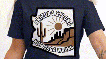 A person wearing a dark blue t-shirt with a graphic design that says "ARIZONA STRONG NOT MAGA WRONG".