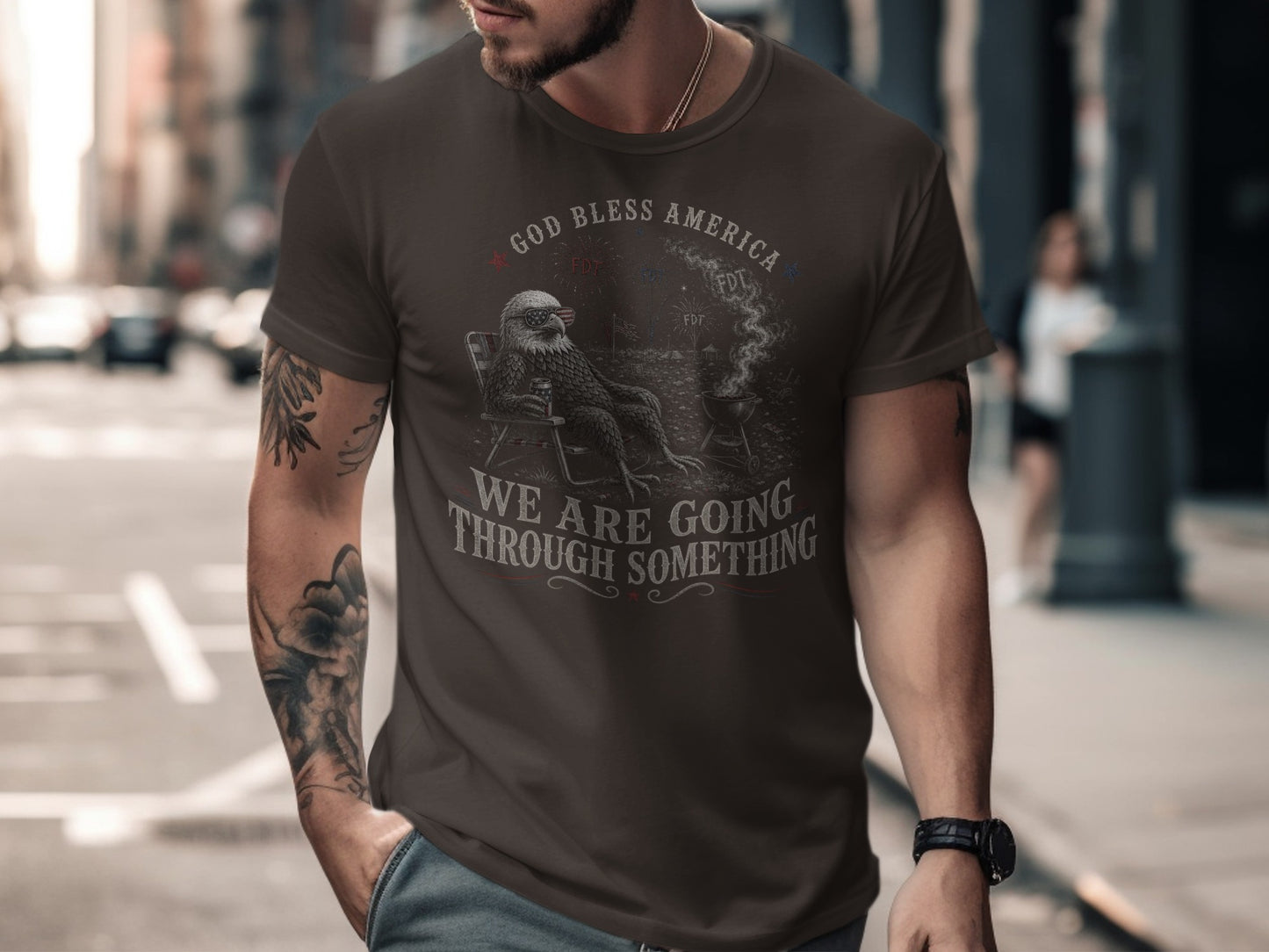 Man wearing a dark t-shirt with "God Bless America We Are Going Through Something" text.