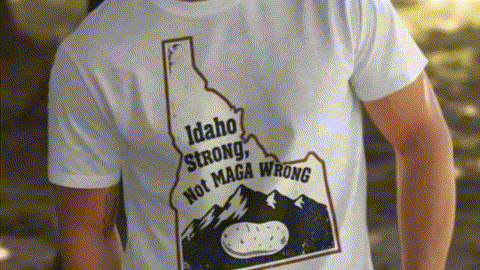 A white t-shirt with a graphic design depicting the state of Idaho and the text "Idaho Strong, Not MAGA Wrong".